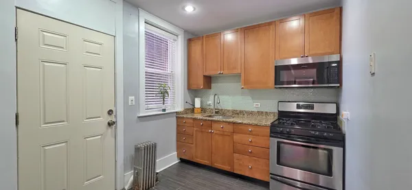 a kitchen with stainless steel appliances granite countertop a stove a sink and a microwave
