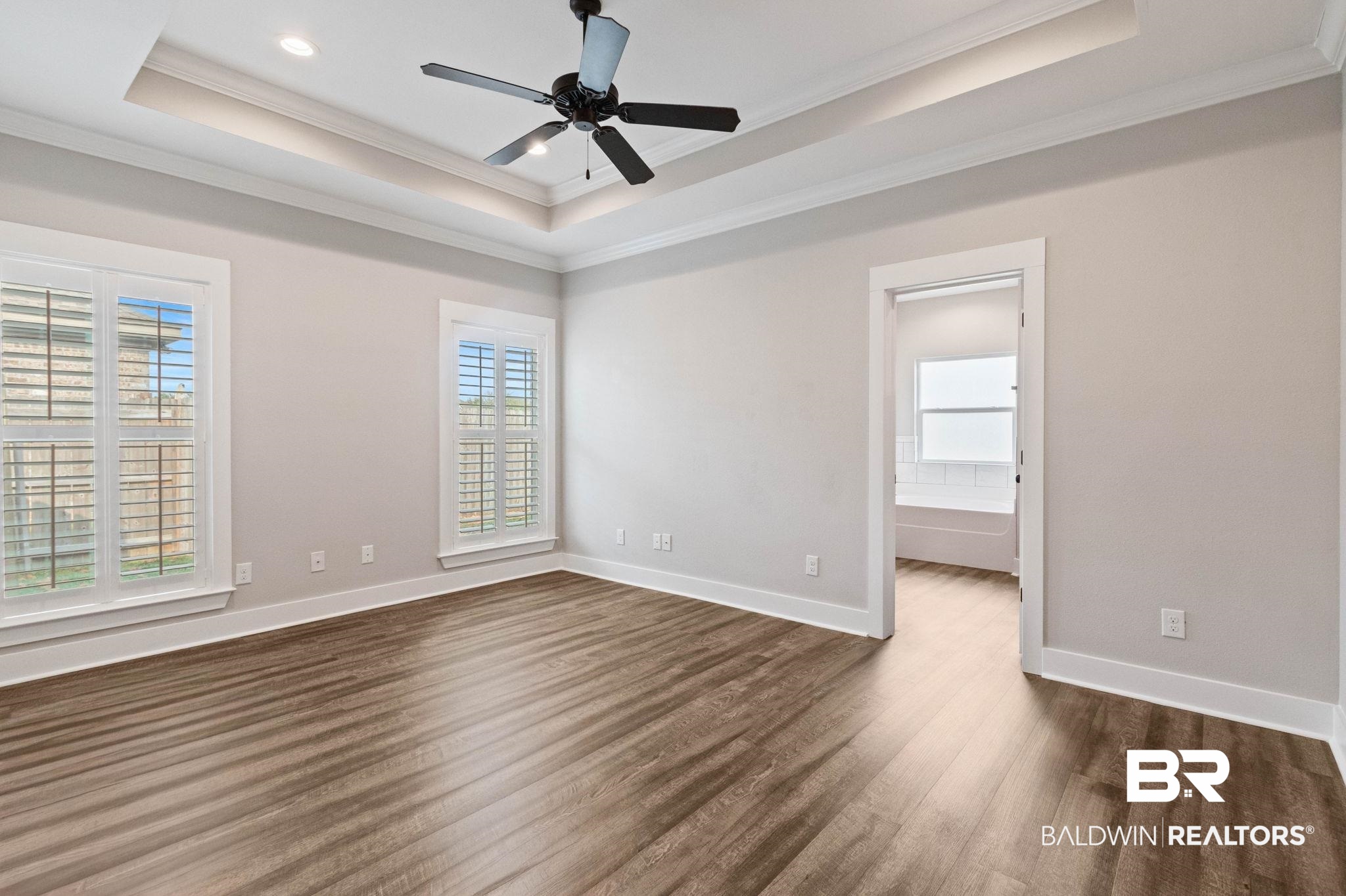 17376 Bankhead Boulevard Fairhope, AL 36532 - Photo 35 of 73 Spare room with crown molding, healthy amount of natural light, a tray ceiling, dark wood-style floors, and a ceiling fan