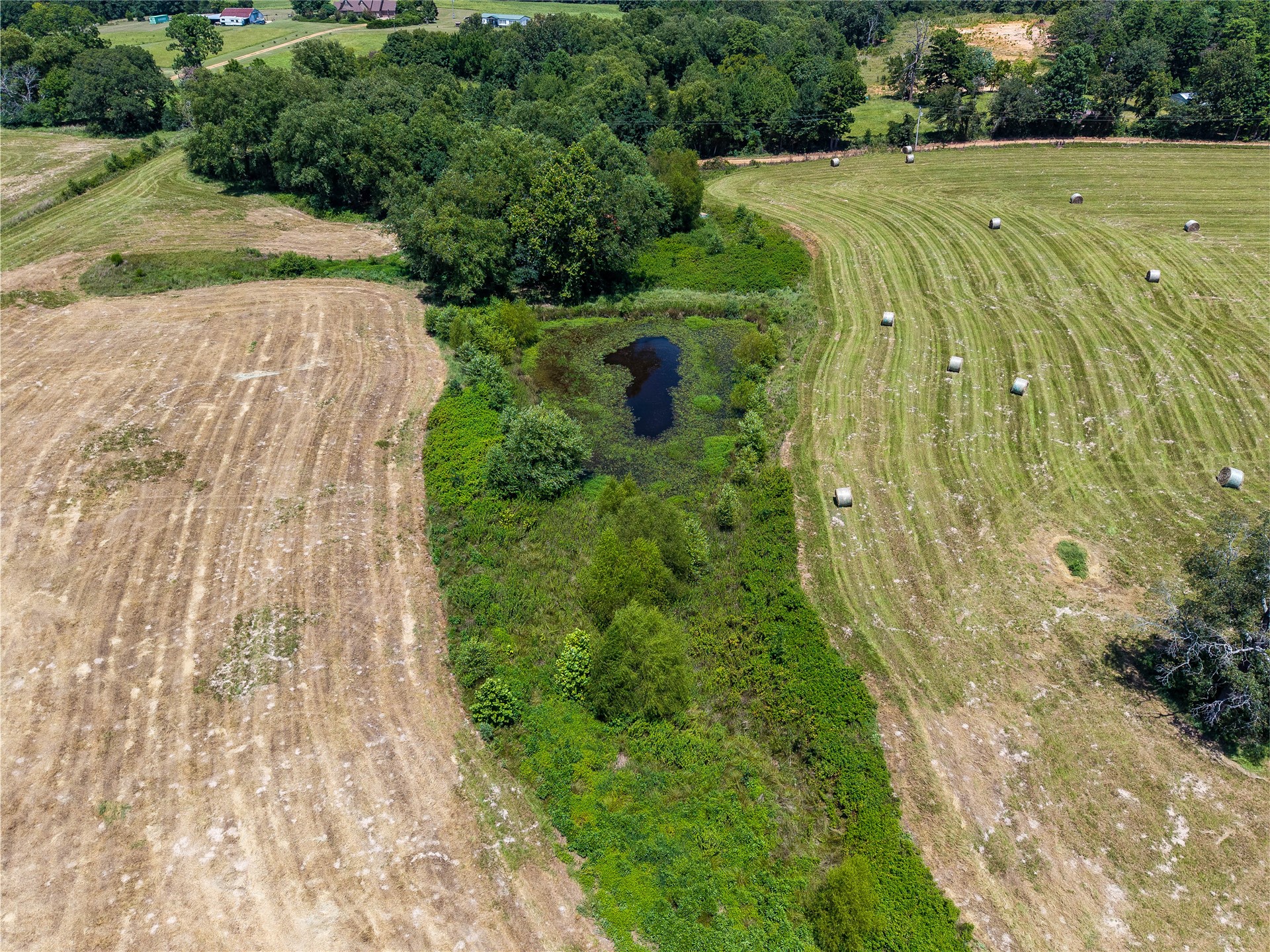 20 Red Hill Road Antlers, OK 74523 - Photo 11 of 17 Aerial overview showcasing agricultural fields with a central pond feature
