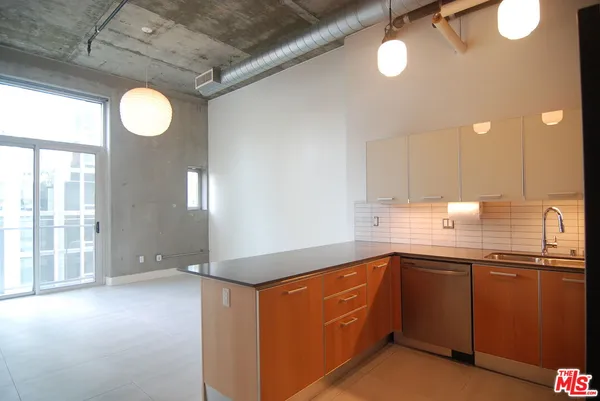 a kitchen with stainless steel appliances granite countertop a sink a stove cabinets and a large window