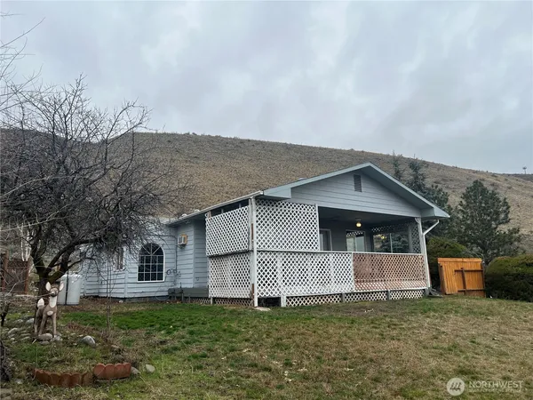 a front view of a house with mountain and yard
