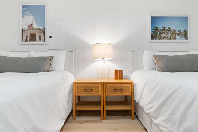 a bedroom with a bed and a lamp on dresser