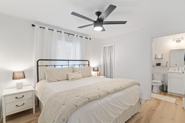 a bedroom with a large bed and a ceiling fan