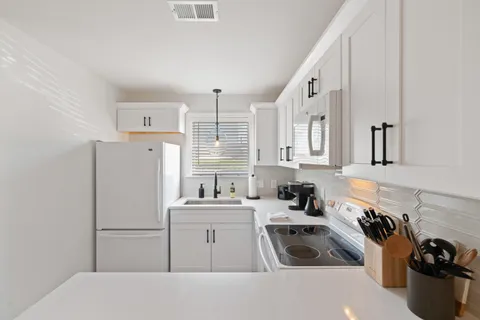 a kitchen with a sink a refrigerator and cabinets