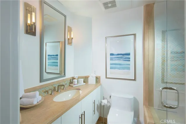 a bathroom with a granite countertop sink mirror vanity and toilet