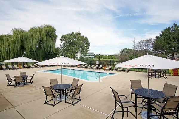 a view of a patio with chairs and a table under an umbrella