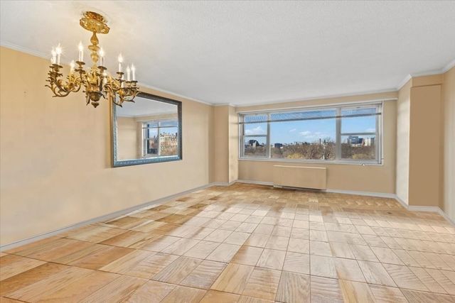 a view of an empty room with a chandelier fan