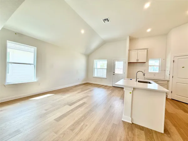 a kitchen with a sink wooden floor and a stove