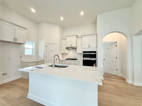 a kitchen with kitchen island a sink stainless steel appliances and cabinets