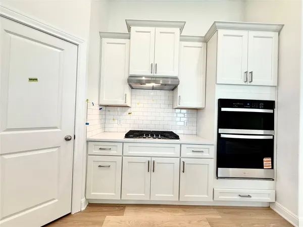 a kitchen with stainless steel appliances white cabinets and stove