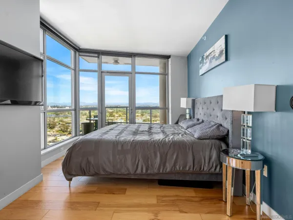 a bedroom with a large bed and a flat tv screen on dresser