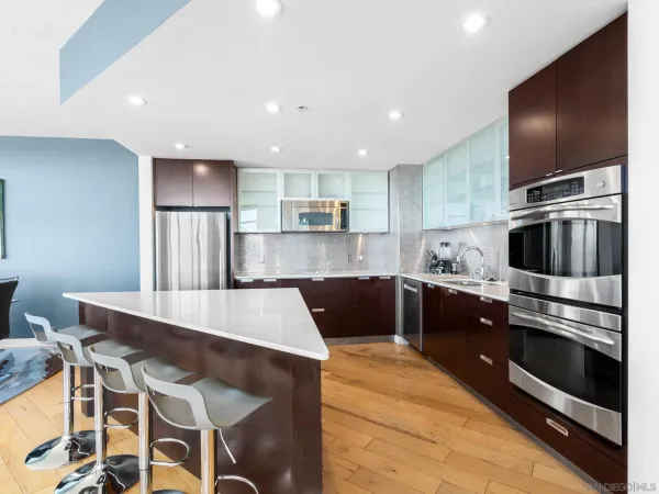 a kitchen with stainless steel appliances kitchen island granite countertop a sink and a stove