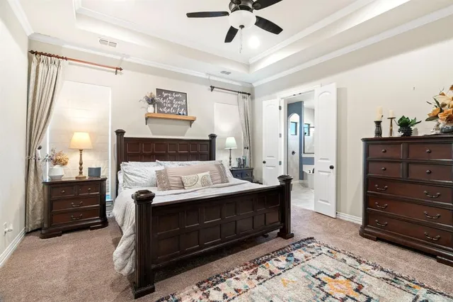 a bedroom with a bed and a lamp on the dresser