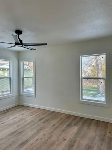 wooden floor in an empty room with a window
