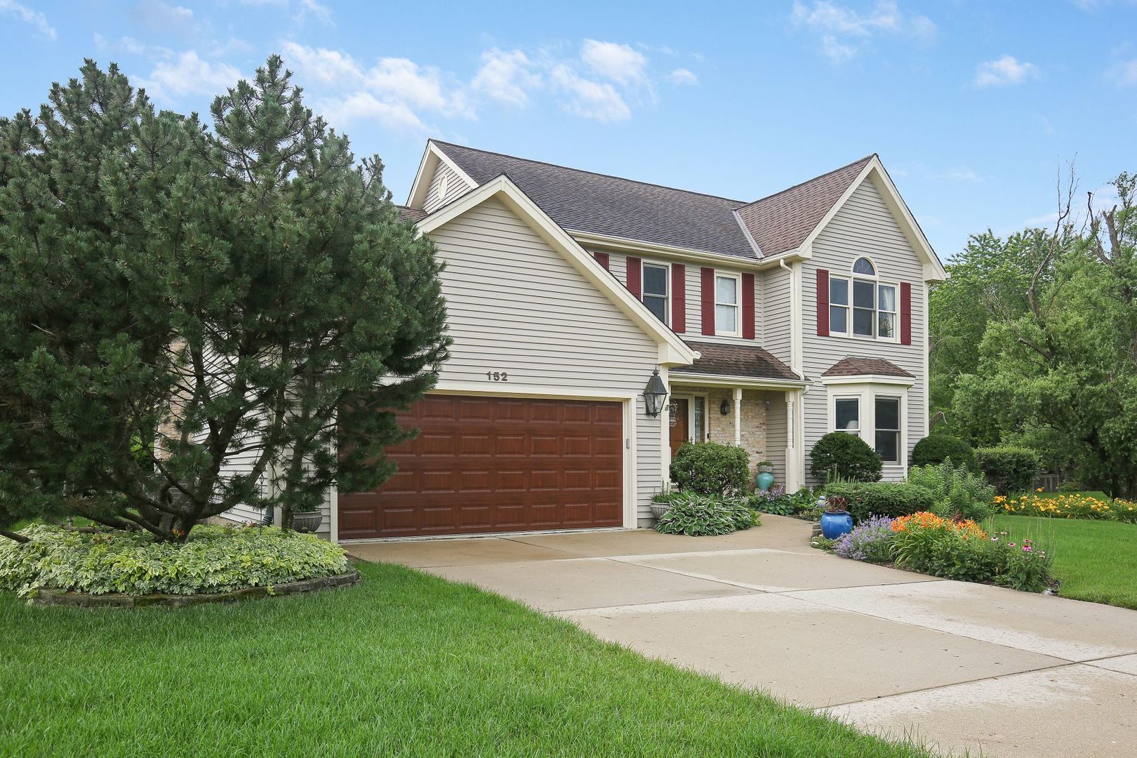 152 Wilcox Drive Bartlett, IL 60103 - Photo 2 of 51 a front view of a house with a garden
