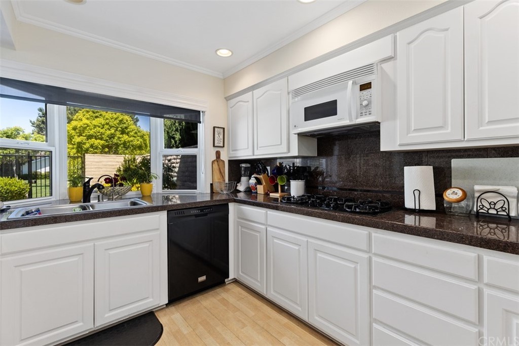 10 Mandrake Way Irvine, CA 92612 - Photo 12 of 35 a kitchen with granite countertop white cabinets and white appliances