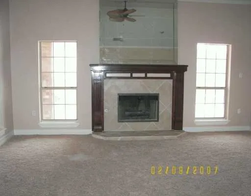 an empty room with a fireplace and windows