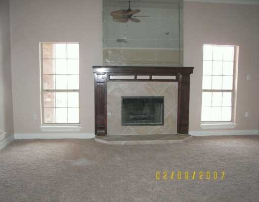 7002 Adcote Drive Corpus Christi, TX 78413 - Photo 2 of 6 an empty room with a fireplace and windows