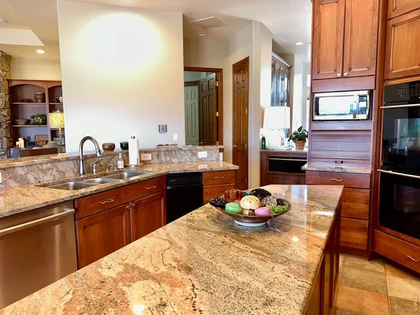 a kitchen with stainless steel appliances kitchen island granite countertop a sink table and chairs