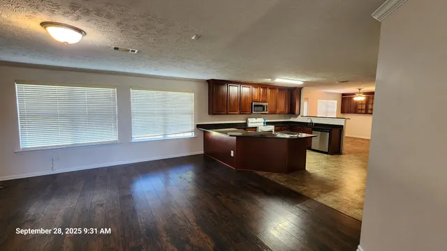 a kitchen with stainless steel appliances granite countertop a stove a sink a refrigerator and a microwave