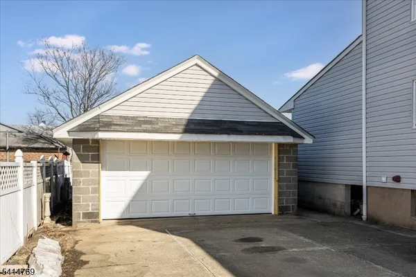 a view of a hallway with wooden floor and a refrigerator