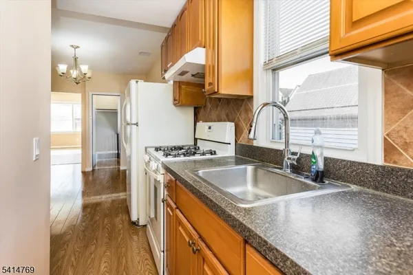 a white refrigerator freezer and a stove sitting inside of a kitchen