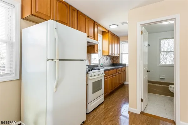 a kitchen with granite countertop cabinets stove top oven and sink