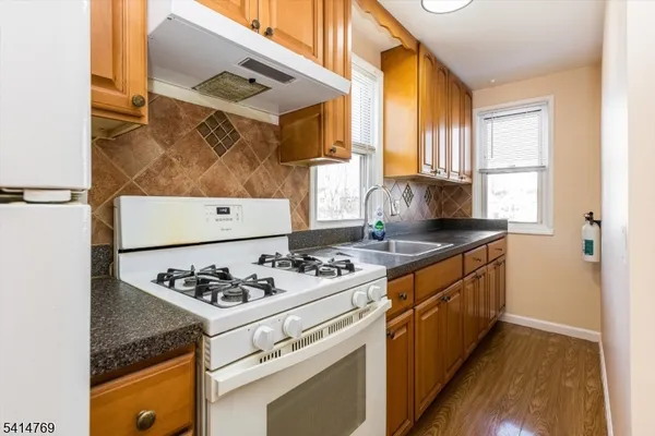 a bathroom with a granite countertop sink and a window