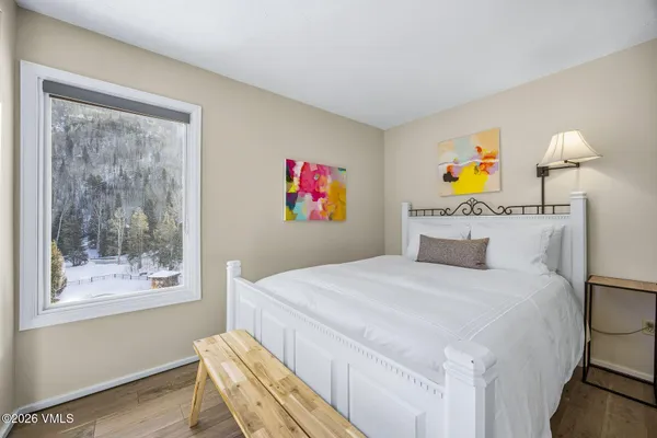 a bedroom with a bed and wooden floor