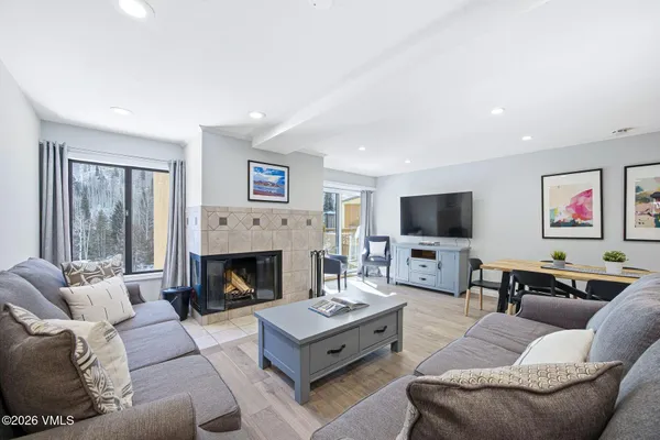 a living room with furniture a flat screen tv and a fireplace