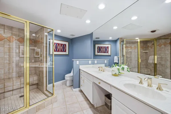 a spacious bathroom with a shower sink and mirror