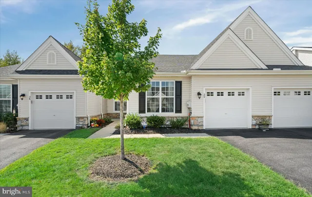 a view of a house with a yard potted plants and a table