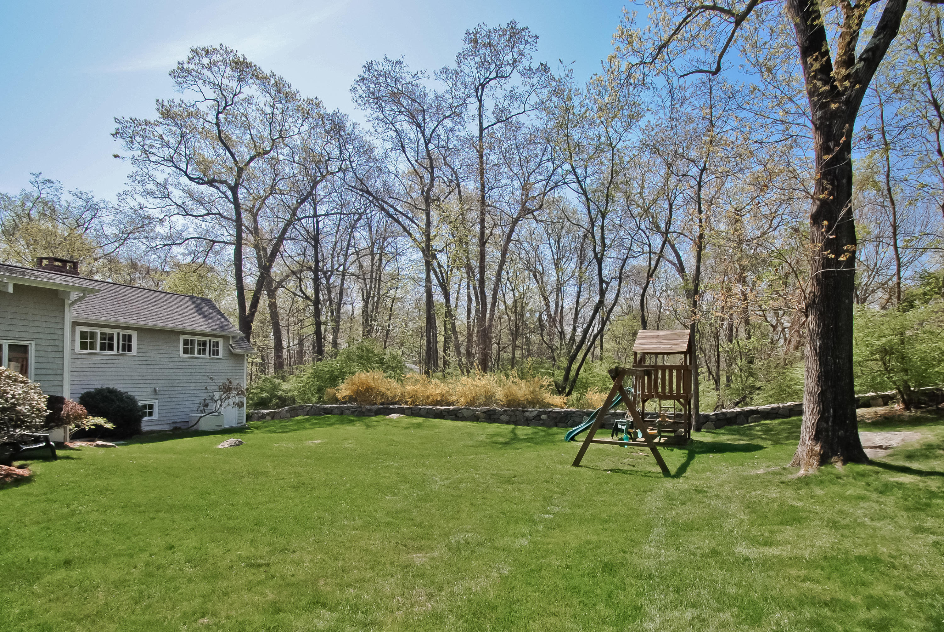 55 Cedar Gate Road Darien, CT 06820 - Photo 38 of 41 a view of a backyard with table and chairs and a large tree