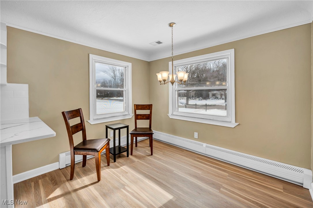 1447 East Sprague Road Independence, OH 44131 - Photo 15 of 47 Sitting room with ornamental molding, a notable chandelier, baseboard heating, and light hardwood / wood-style flooring