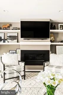 a kitchen with granite countertop a refrigerator a stove a sink dishwasher and white cabinets with wooden floor