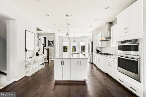 a large kitchen with stainless steel appliances a stove a sink dishwasher and a refrigerator