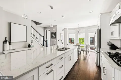 a bedroom with a bed a chandelier mirror and a window