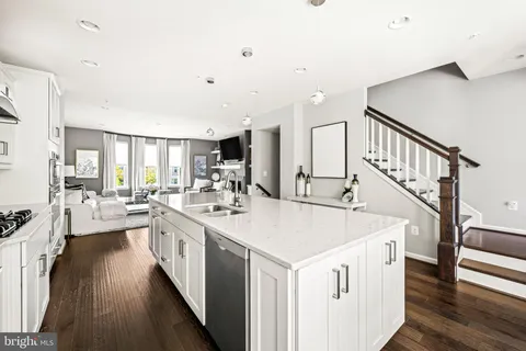 an empty room with wooden floor cabinet and windows