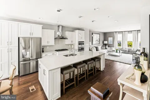 an empty room with wooden floor closet and windows