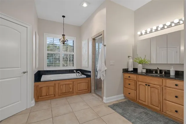 a kitchen with stainless steel appliances kitchen island granite countertop a table chairs and a refrigerator