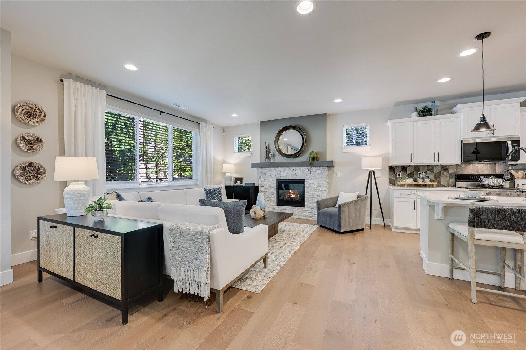 19221 Meridian Drive Southeast, Unit CW 16 Bothell, WA 98012 - Photo 18 of 37 a living room with furniture a fireplace kitchen view and a large window