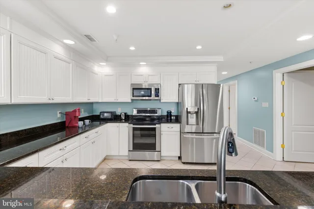 a view of a bedroom with a bed and a lamp