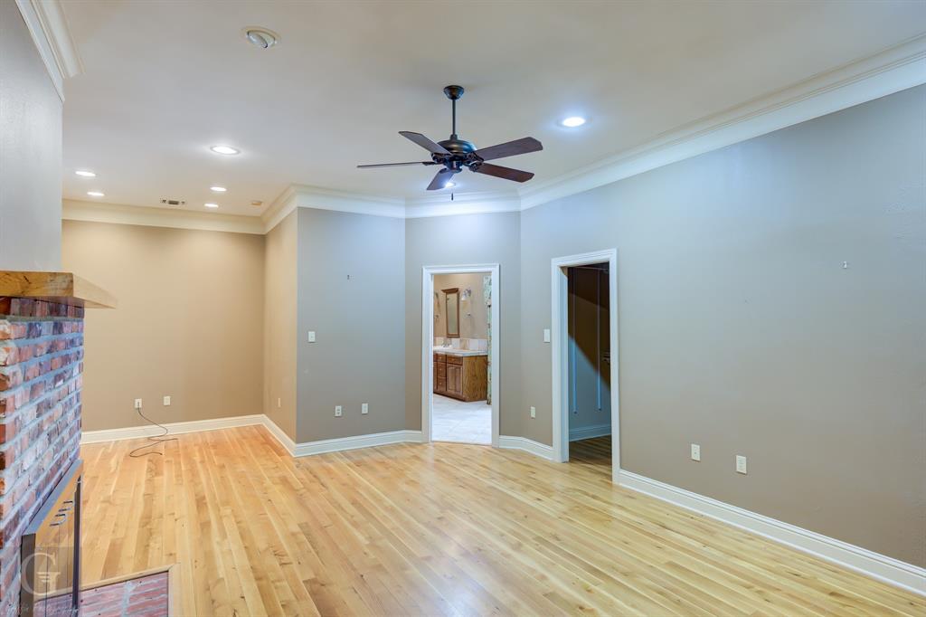 1212 WPA Road Homer, LA 71040 - Photo 19 of 35 Unfurnished living room with ceiling fan, crown molding, light wood-type flooring, a fireplace, and baseboards