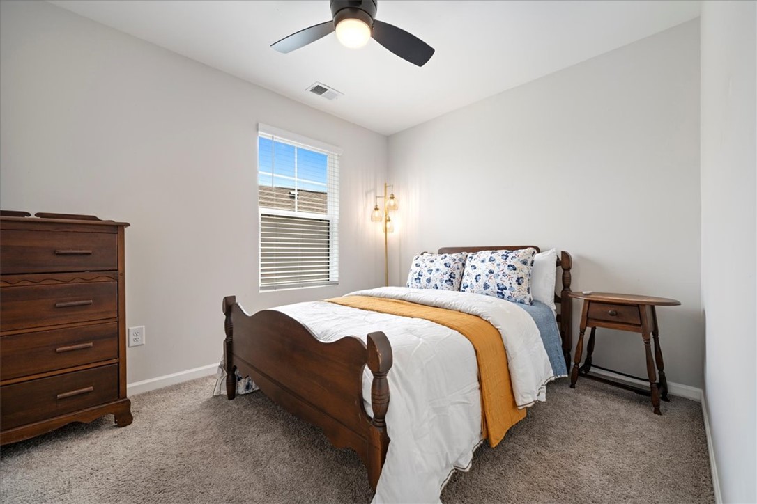 117 Adger Road Pendleton, SC 29670 - Photo 20 of 36 This cozy bedroom features a ceiling fan, plush carpet, and ample natural light.