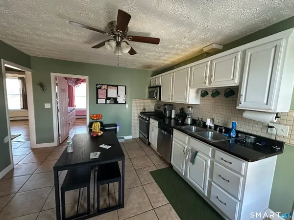 a kitchen with granite countertop a sink a counter space stainless steel appliances and cabinets