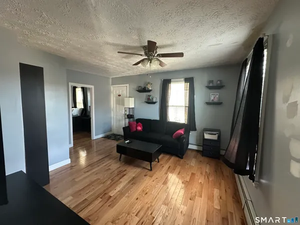 a living room with furniture and wooden floor