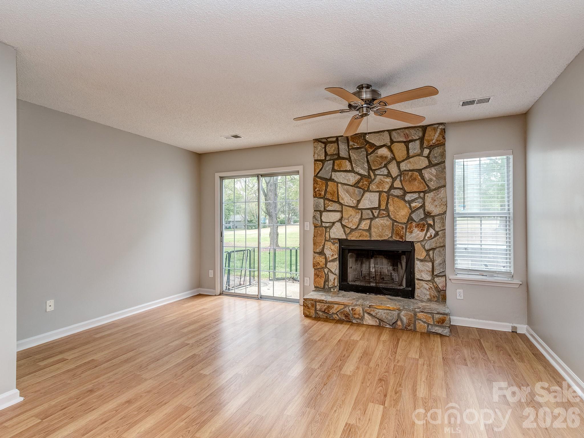8211 Golf Ridge Drive Charlotte, NC 28277 - Photo 13 of 40 an empty room with windows a fireplace and wooden floor
