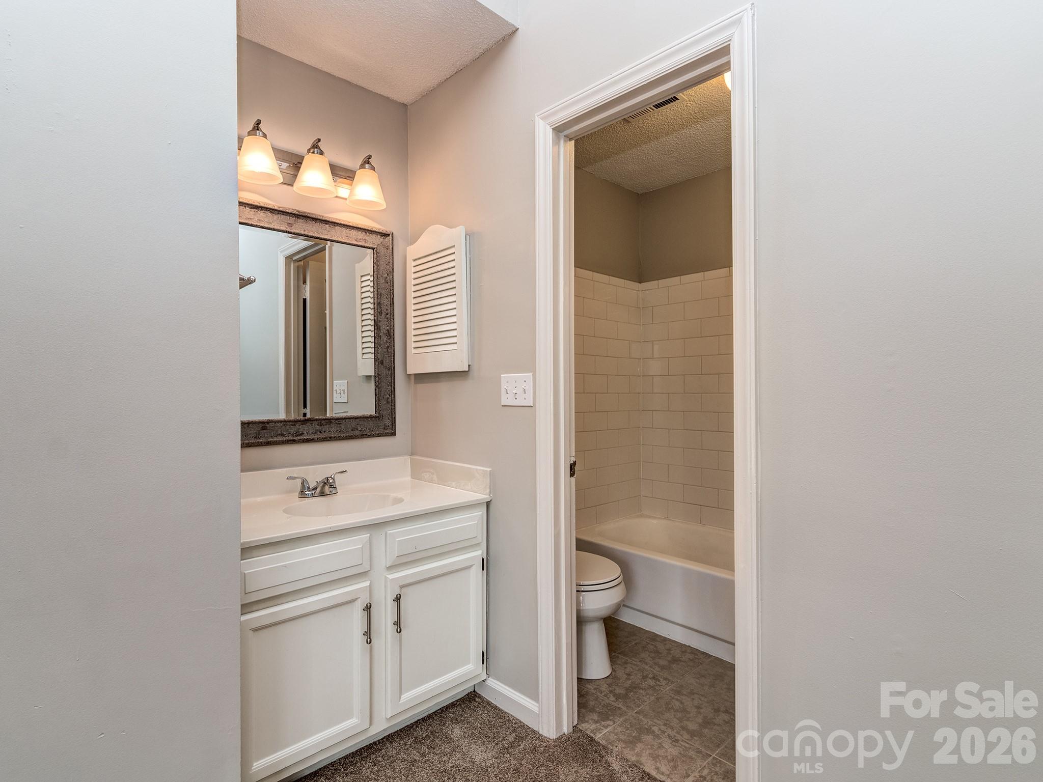8211 Golf Ridge Drive Charlotte, NC 28277 - Photo 21 of 40 a bathroom with a toilet sink and mirror