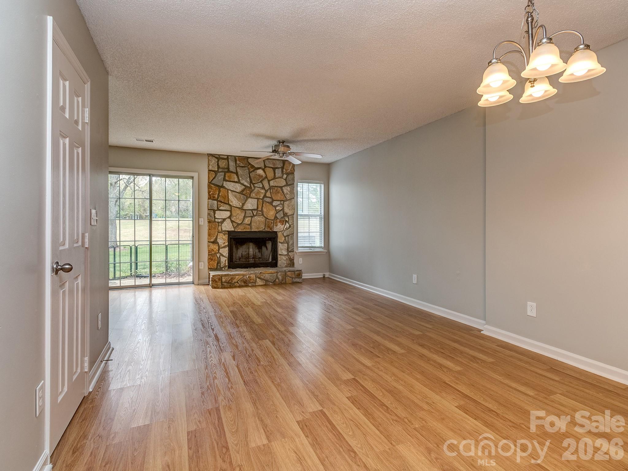 8211 Golf Ridge Drive Charlotte, NC 28277 - Photo 7 of 40 a view of empty room with wooden floor and fireplace