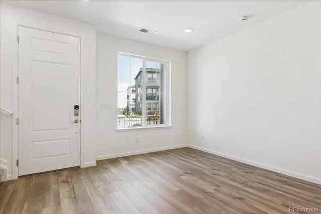 an empty room with wooden floor and window